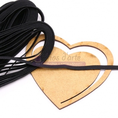 Fios elásticos pretos finos sobre base de madeira em forma de coração