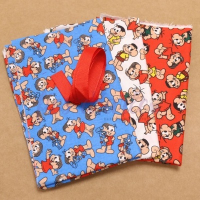 Tecidos coloridos com estampado de personagens de banda desenhada e fita vermelha