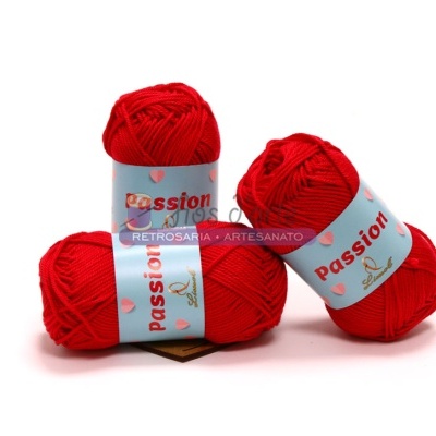 Três novelos de lã vermelha com rótulos azuis claros