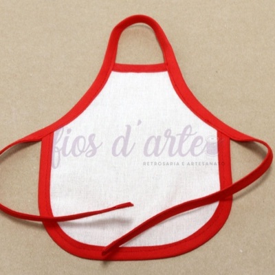Avental branco com bordas vermelhas e fitas para amarrar numa superfície bege