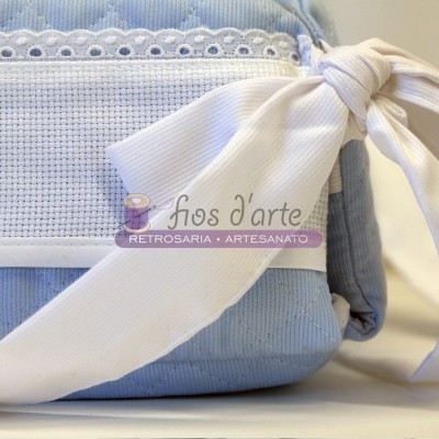 Mala azul clara com laço branco e detalhes bordados