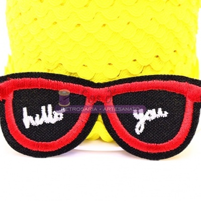 Patch bordado de óculos de sol com 'hello you' em tecido preto, bordas vermelhas, fundo amarelo texturizado
