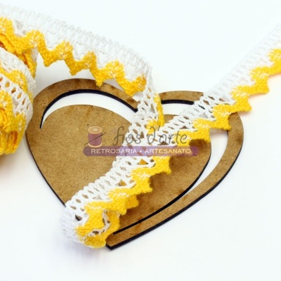 Fita rendada amarela e branca sobre base de cartão em forma de coração com texto de artesanato