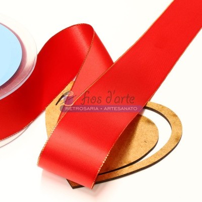 Fita vermelha com bordas douradas sobre bobina e coração de madeira