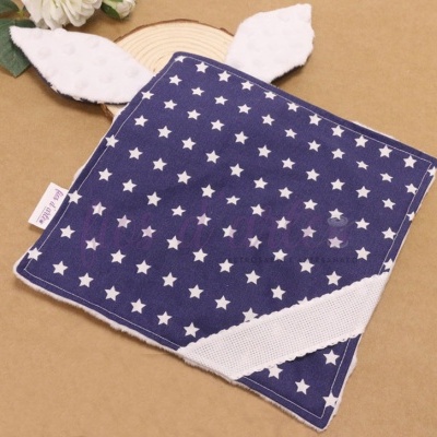 Quadrado de tecido azul com estrelas brancas e detalhes em branco com recortes em forma de orelhas