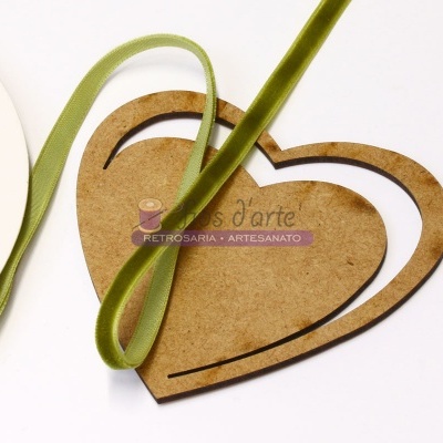 Molde de coração em madeira fina com fita verde de tecido sobre superfície branca