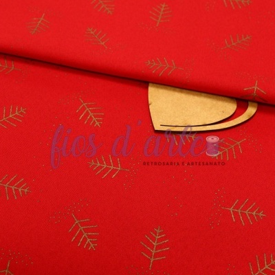 Tecido vermelho com padrão dourado de folhinhas e objeto de madeira