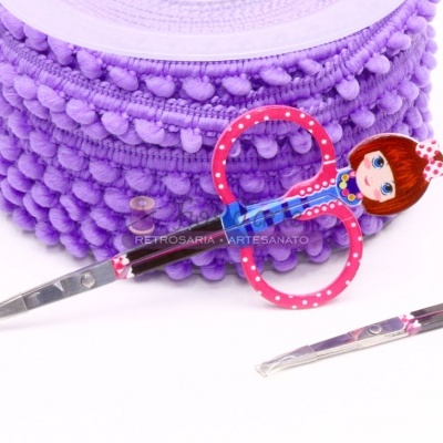Tesouras coloridas com cabo em forma de boneca junto a fita de pompons lilás