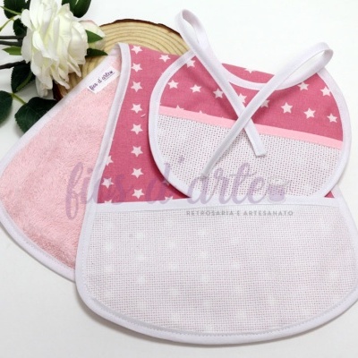 Dois babetes de bebé rosa claro com estrelas e branco sobre fundo branco com flor branca