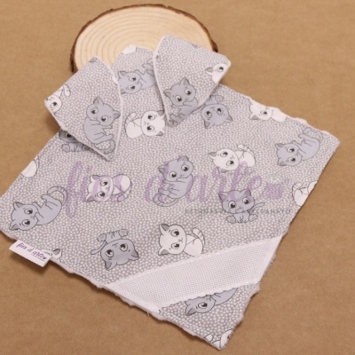 Conjunto de panos cinzentos com padrão de animais sobre madeira clara