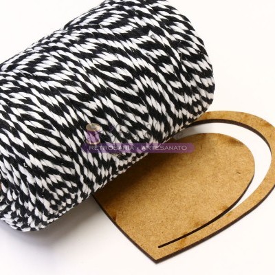 Bobina de fio preto e branco e molde de coração em cartão