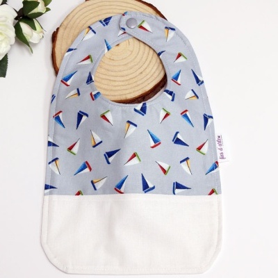 Babete para bebé com padrão de velas de barco em azul claro e branco