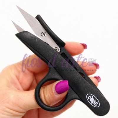 Tesoura pequena com cabo preto segurada na mão