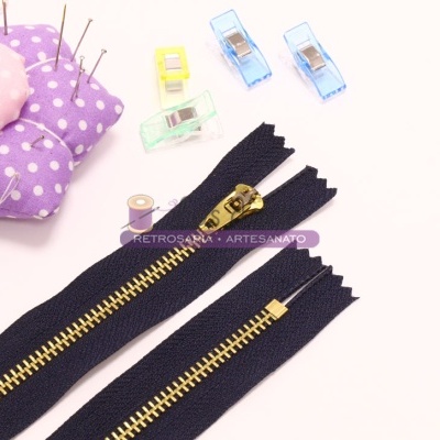 Fechos de correr pretos, alfineteiro de flor, prendedores coloridos e carretel de linha.