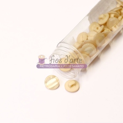 Frasco de botões creme transparentes com texto 'fios d'arte'