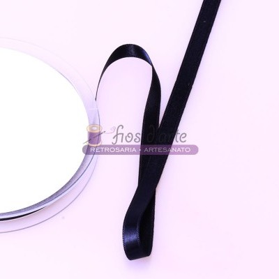 Rolo de fita de cetim preta contra fundo rosa claro