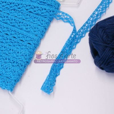 Fita de croché azul clara e novelo de lã azul escuro sobre superfície branca