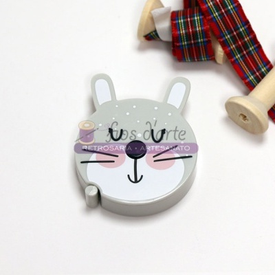 Cabide de coelho em madeira ao lado de fitas xadrez em carretéis