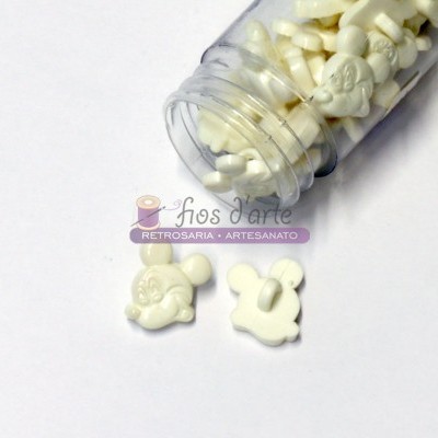 Frasco aberto com botões brancos em formas diversas sobre fundo branco