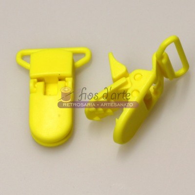Dois clips de plástico amarelo com fecho sobre fundo claro