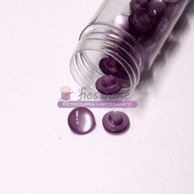 Frasco transparente com botões roxos translúcidos sobre fundo branco