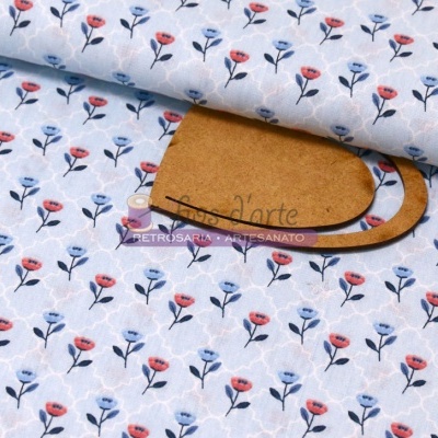 Tecido branco com padrão floral azul e vermelho sobre base de madeira com etiqueta