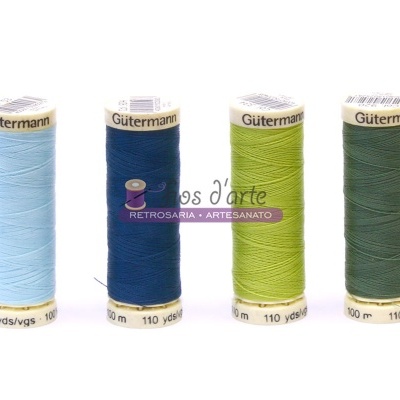 Quatro carretéis de linha Gütermann em diferentes tons de azul e verde