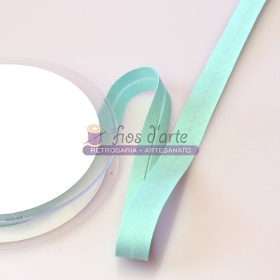 Fita decorativa verde-água em rolo transparente sobre superfície clara