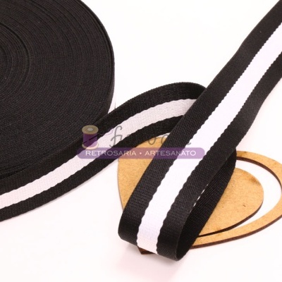 Fita elástica preta com listra branca sobre fundo branco e objeto redondo de madeira