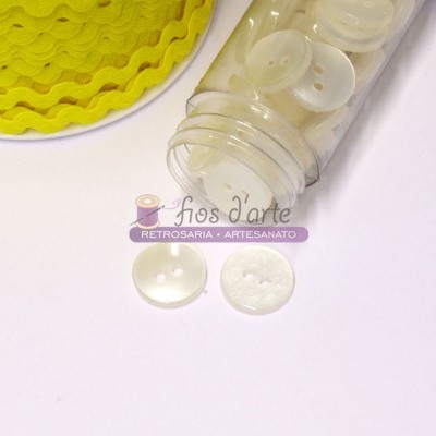 Botões brancos e cordão amarelo em frasco e superfície