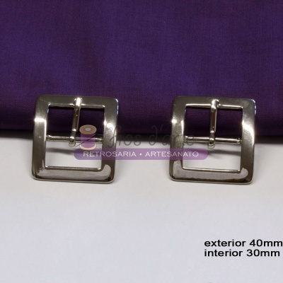 Duas fivelas metálicas prateadas quadradas com tecido roxo ao fundo