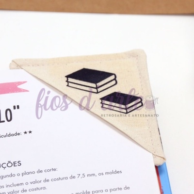 Marcador de livro em tecido bege com livros pretos