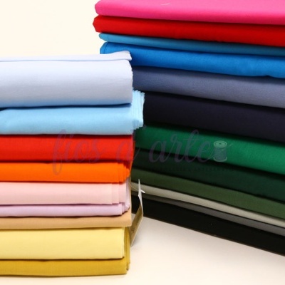 Pilha de tecidos coloridos lisos empilhados sobre superfície branca