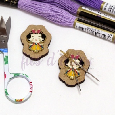 Tesouras com padrão floral, alfinetes de marcação com personagem infantil, agulhas e novelos de linha lilás
