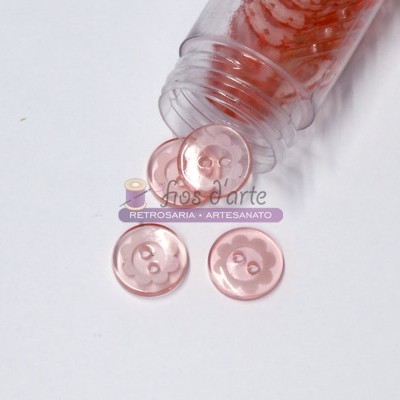 Botões cor-de-rosa translúcidos com quatro furos numa superfície branca