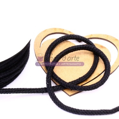 Cordão preto trançado sobre corações de madeira clara, com tiras de material preto ao lado