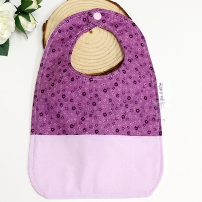 Babete de bebé roxo e lilás com padrão floral e botão de pressão