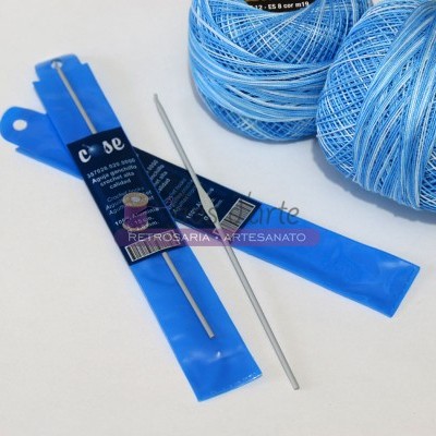 Novelos de linha azul clara com agulhas de metal para crochet