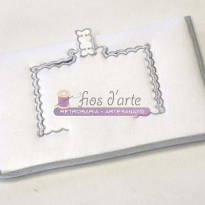 Estojo branco com borda cinza e bordado com urso pequeno e etiqueta com texto 'fios d'arte RETROSARIA • ARTESANATO'