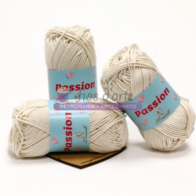 Três novelos de fio de algodão creme com rótulos azuis