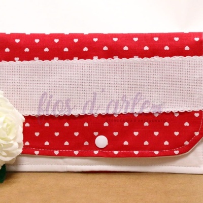 Carteira vermelha com corações brancos e faixa branca com texto 'lios d'arte'