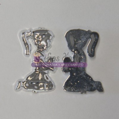 Dois pendentes em forma de troféu com acabamento prateado e preto, sobre fundo branco