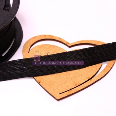 Fita elástica preta fina sobre peça de madeira em forma de coração branca com texto
