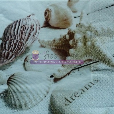 Guardanapo de papel branco com conchas do mar e texto 'dreams'