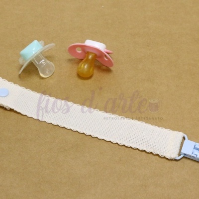 duas chuchas de silicone e fita com clip azul em fundo castanho