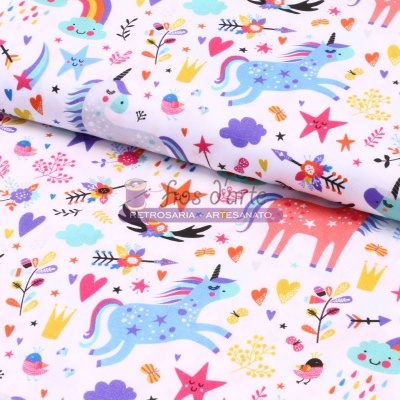 Tecido branco estampado colorido com unicórnios e elementos mágicos.