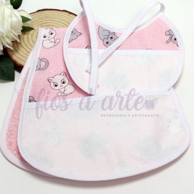 Dois babetes rosa com padrão de gatinhos e pala de tela branca