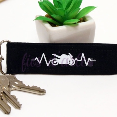 Chaveiro preto com estampa de moto e linhas de batimentos cardíacos