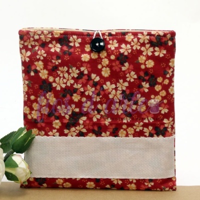 Estojo tecido florido vermelho com botão preto e faixa branca