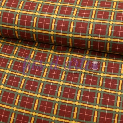 Tecido xadrez vermelho, amarelo e bege enrolado sobre mesa branca.